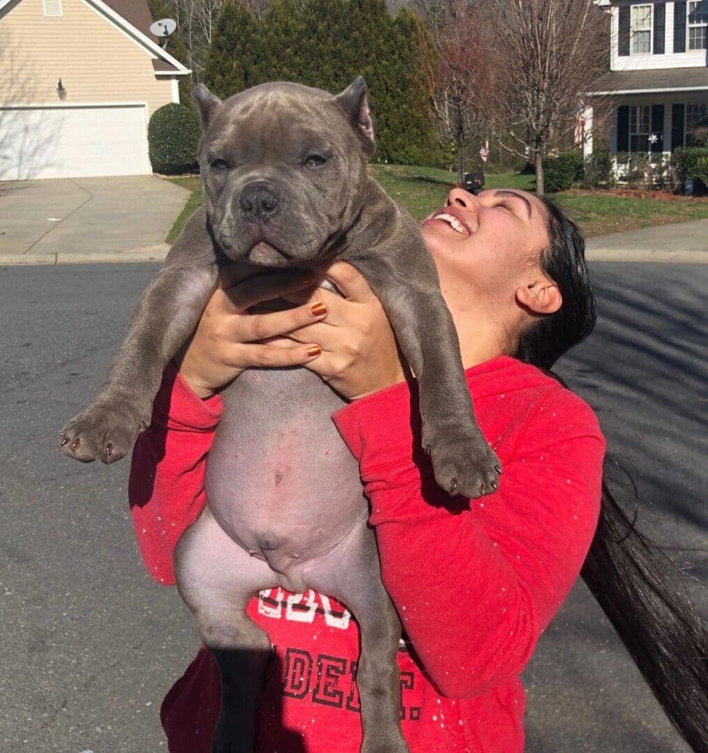 A woman holding a dog in her arms.