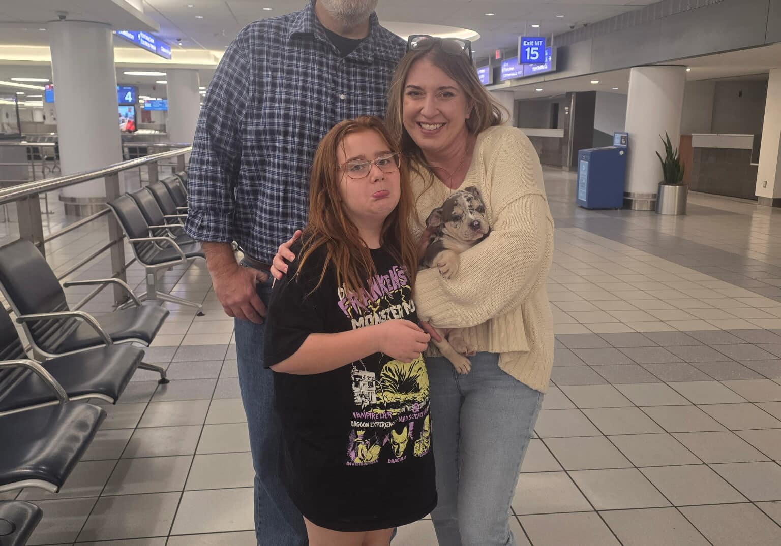 Portia and Jason meeting Southeast Bully Kennels’ nanny, Veronica, at the airport to receive their new Micro Bully puppy from the Icepick × River breeding.