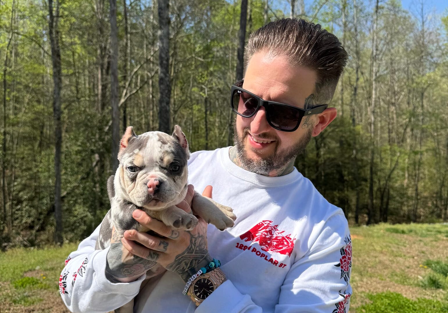 Matt holding Winnie, his tri merle micro bully puppy, on the day she went home from Southeast Bully Kennels, capturing the moment he received her as his birthday gift.