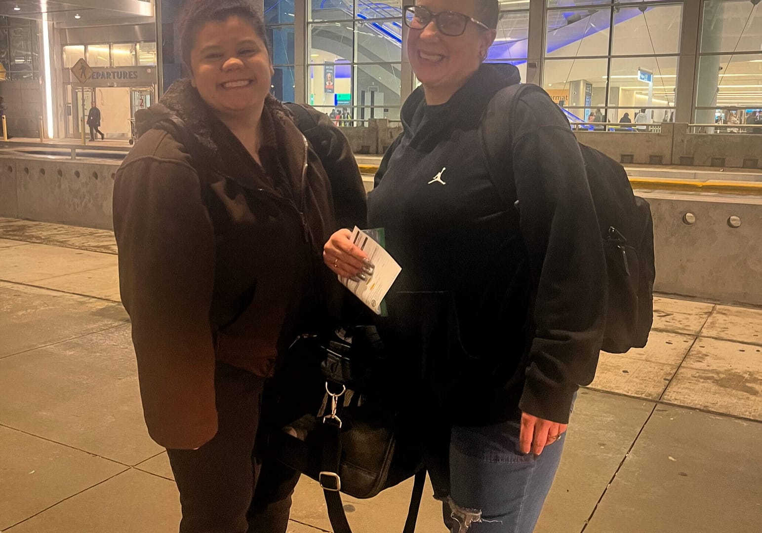 two ladies at the airport with puppies in a puppy transport carrier, delivering puppies to families across the United States
