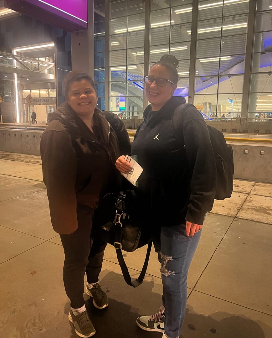 two ladies at the airport with puppies in a puppy transport carrier, delivering puppies to families across the United States