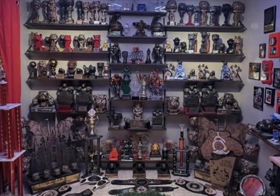 Room filled wall-to-wall with micro and pocket American Bully trophies, championship belts, statues, plaques, and awards displayed on shelves at Southeast Bully Kennels.